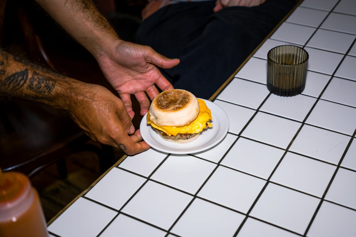 A breakfast muffin on a plate on a counter