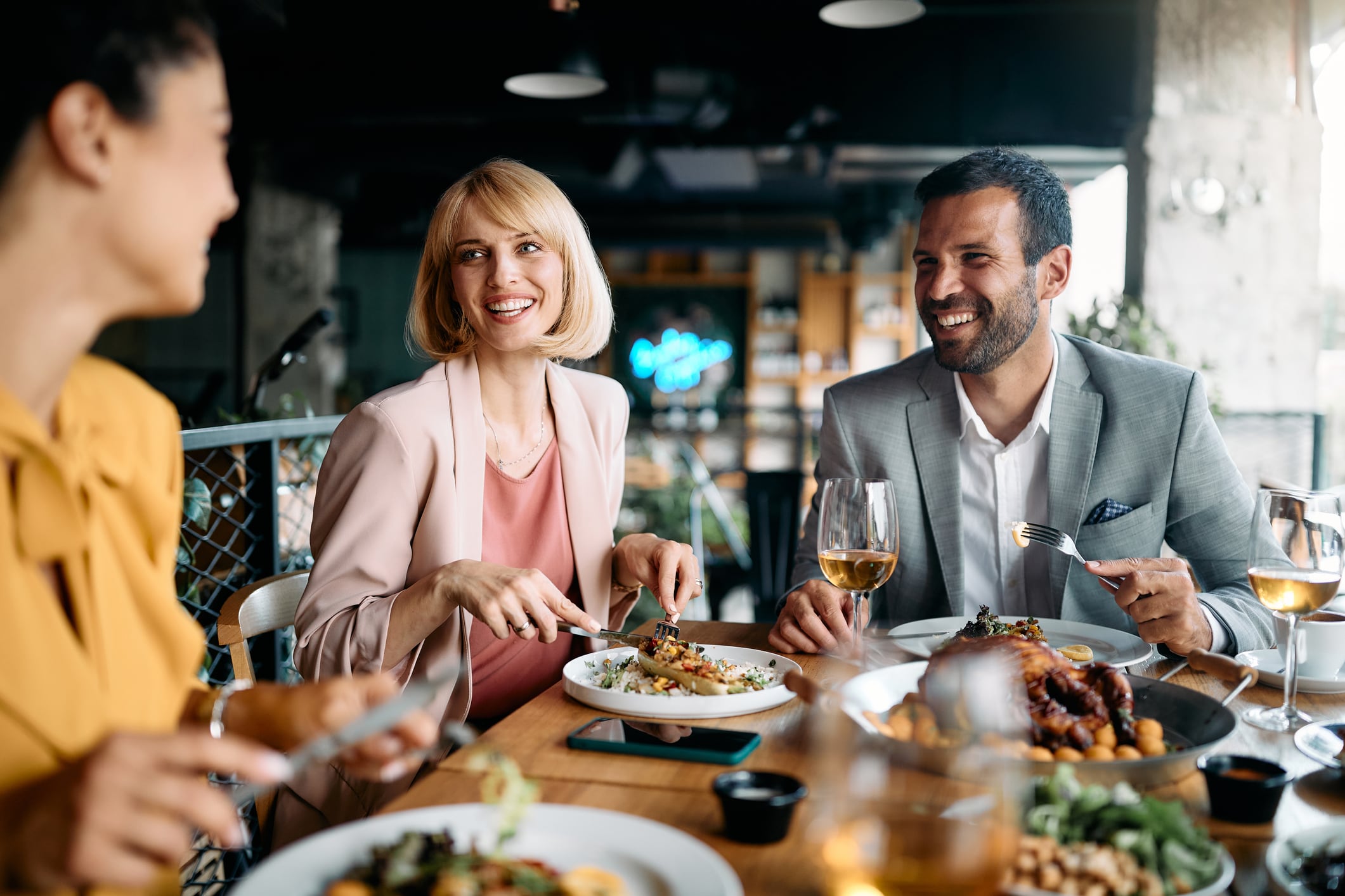 A group of business people toasting a deal over  food and drink