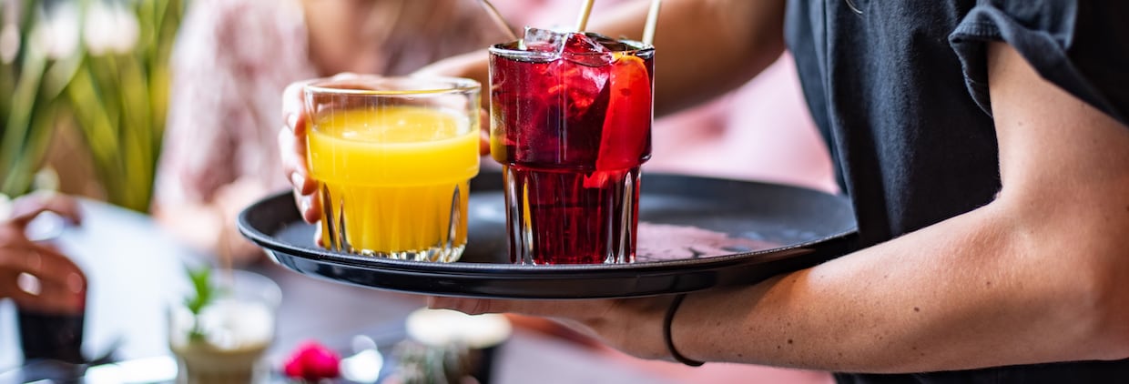 Server carrying drinks to restaurant table