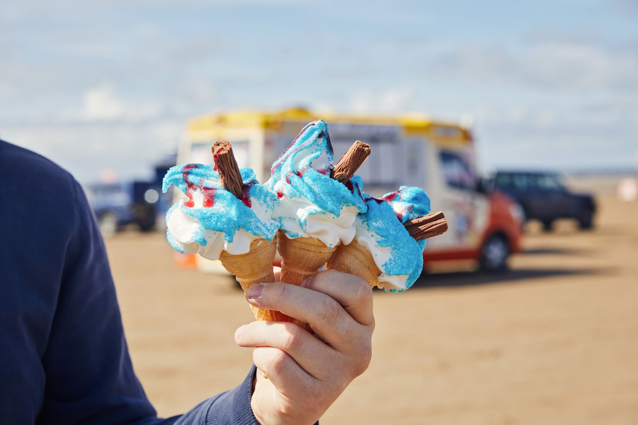 man holding three ice cream cone infant of the ice cream van
