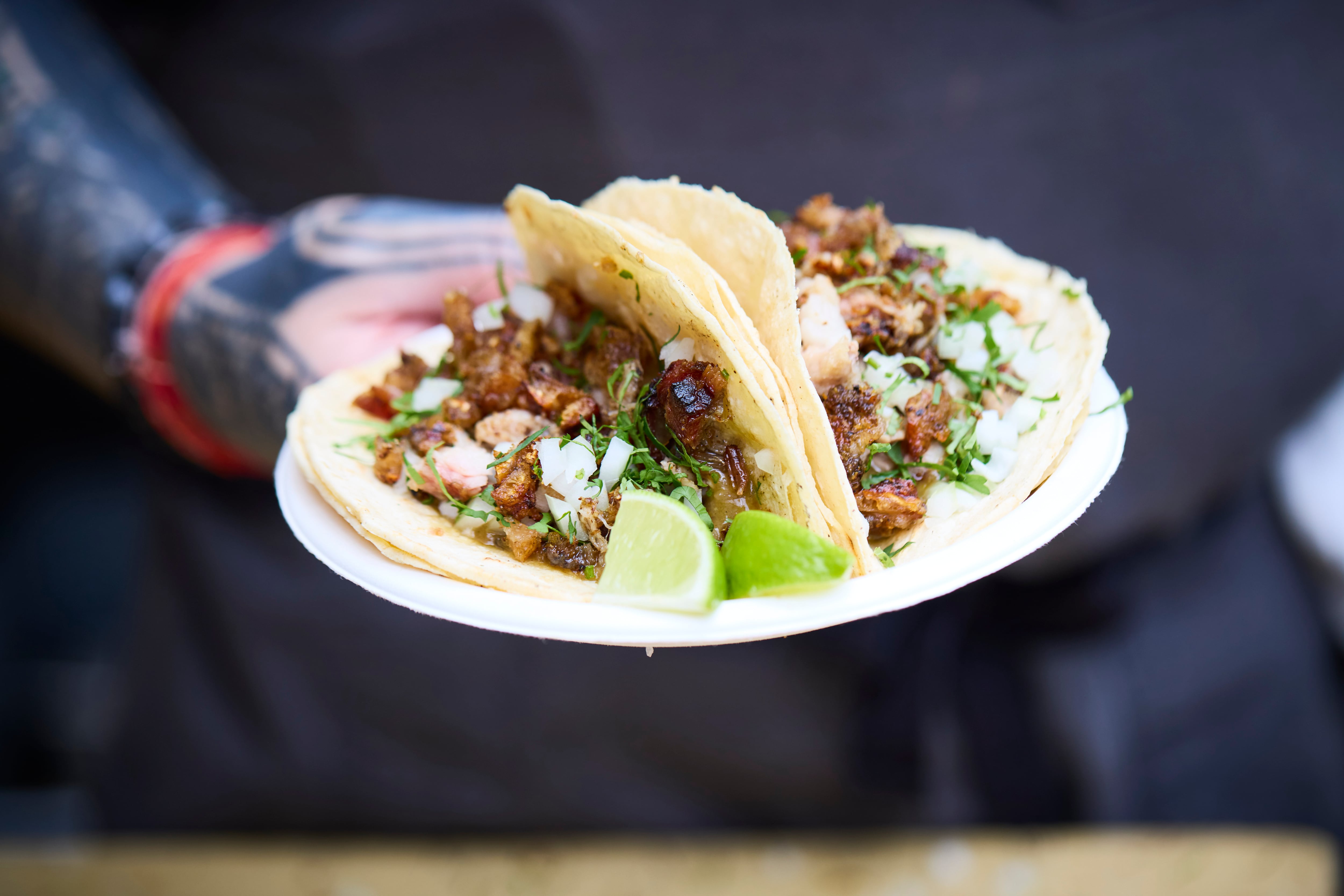 A plate of tacos being held out at Acme Taco