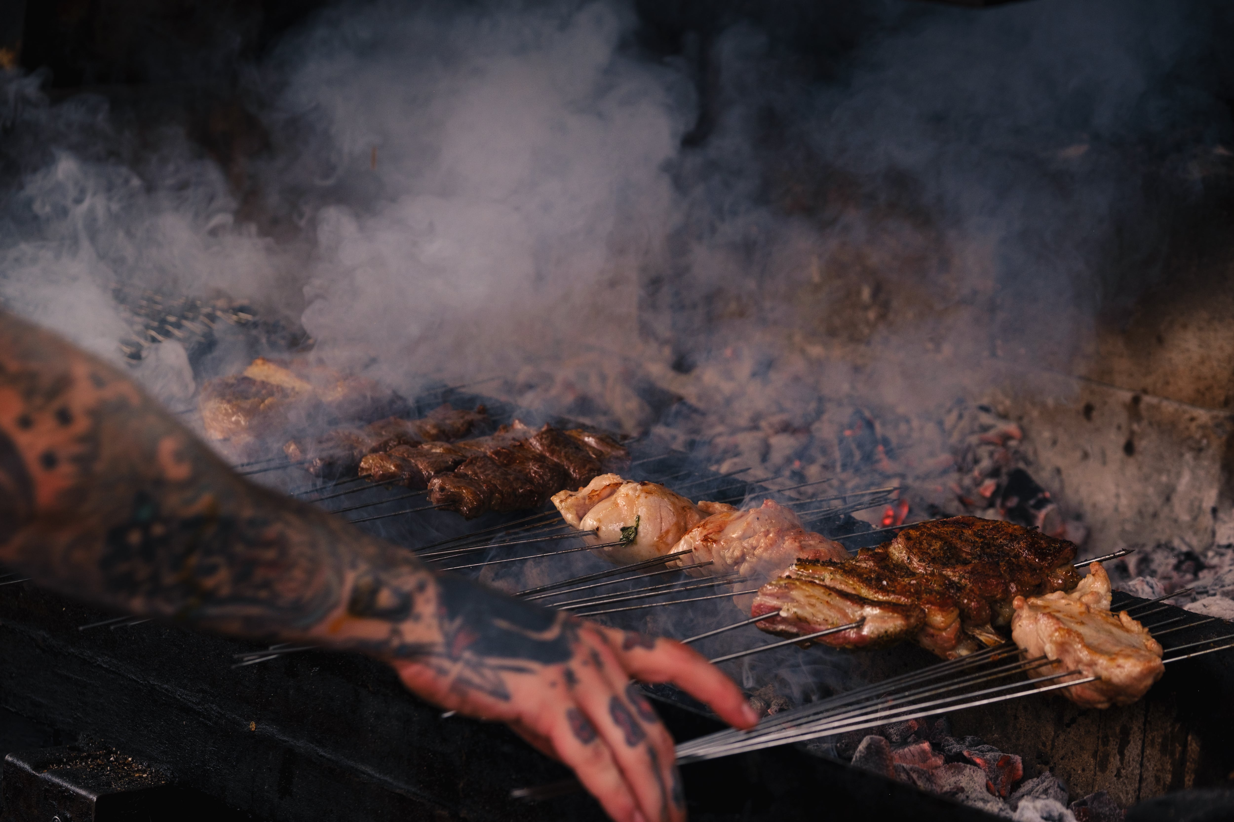 Skewers of meat being cooked over charcoal