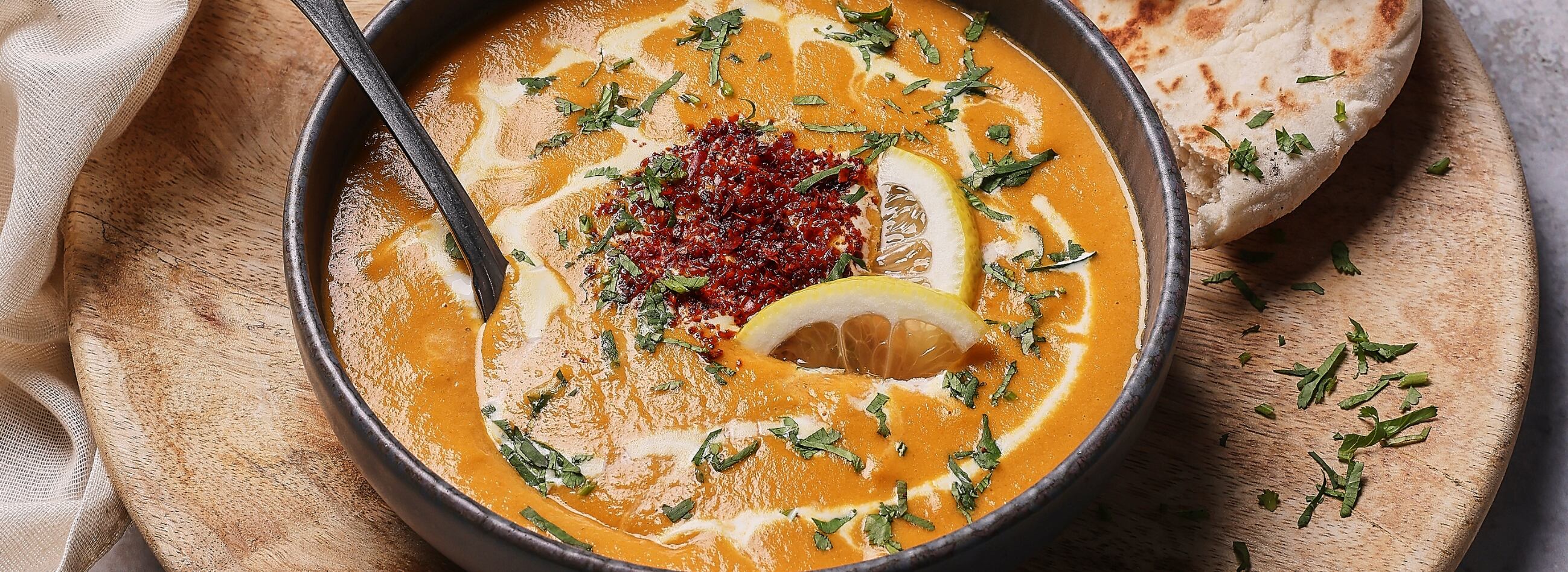 Bowl of soup on a board with bread