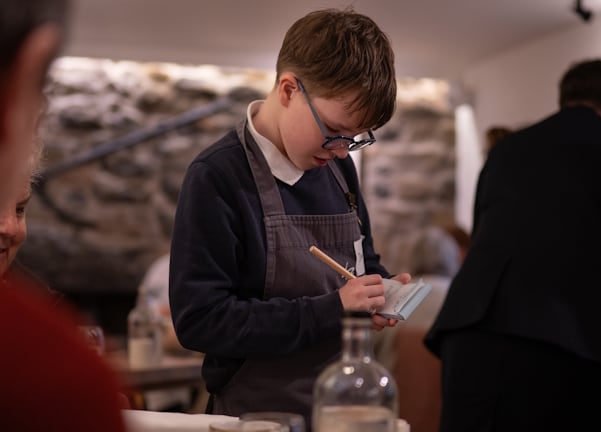Junior chef programme participant taking orders