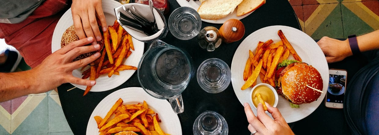 Overhead shot of burgers and sweet potato fries on plates in a restaurant