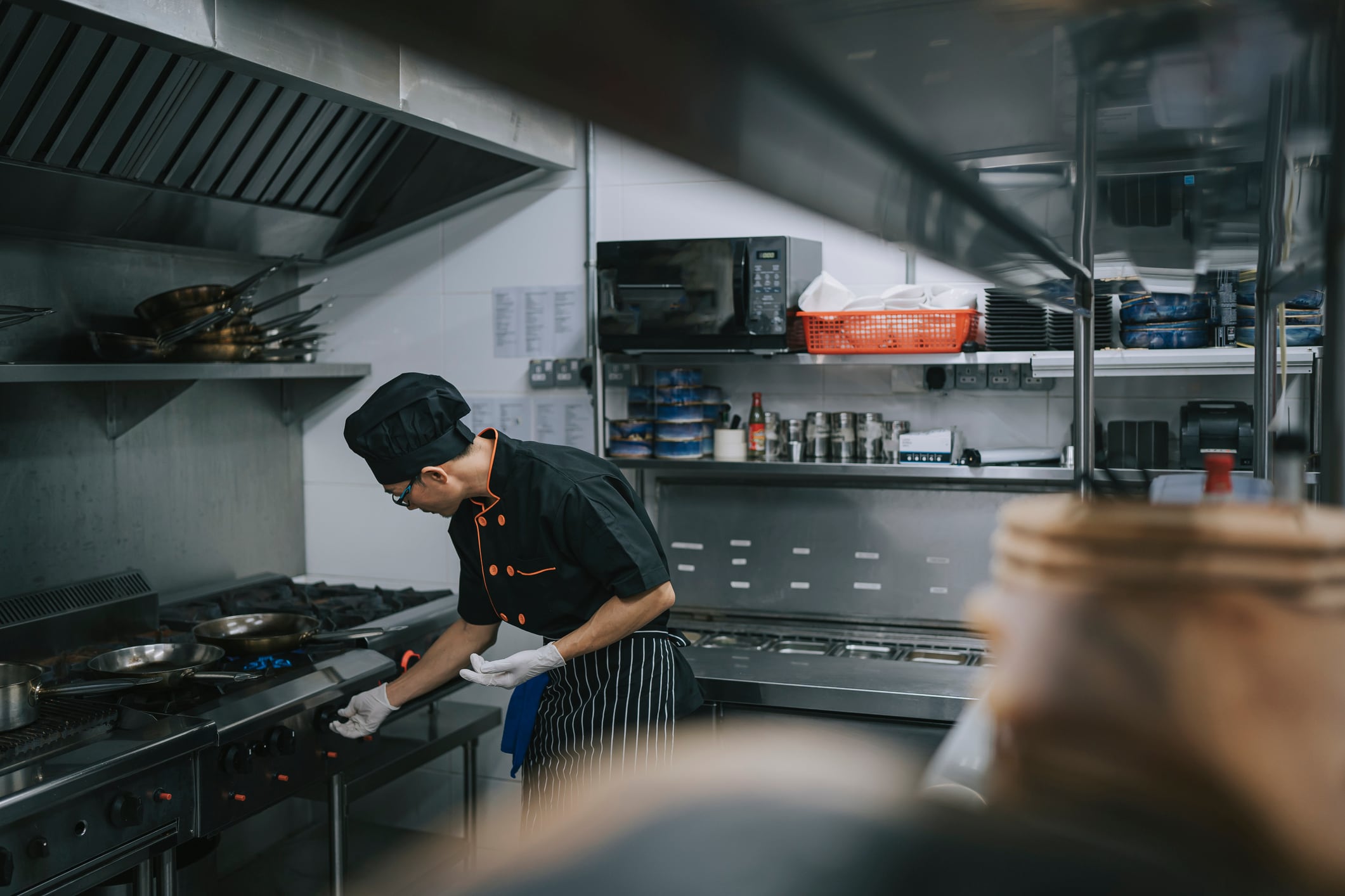 Asian Chinese Chef turn on gas stove, preparing to cook as routine in kitchen
