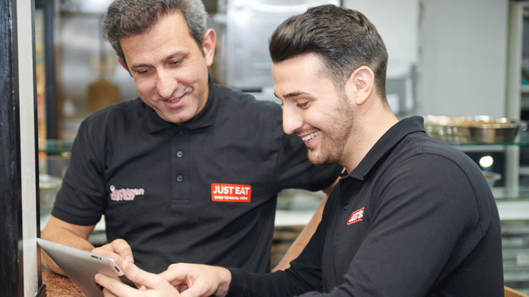 JustEat-employees-looking-at-tablet